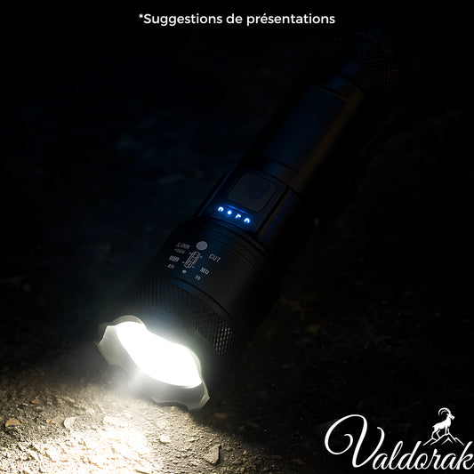 Lampe torche LED étanche Valdorak allumée sur sol sombre avec lumière intense